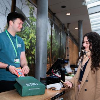 Retail team member serving customer in Eden Project shop